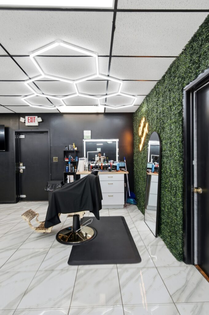 Barber chair beside the living moss wall at Golden Barbershop.